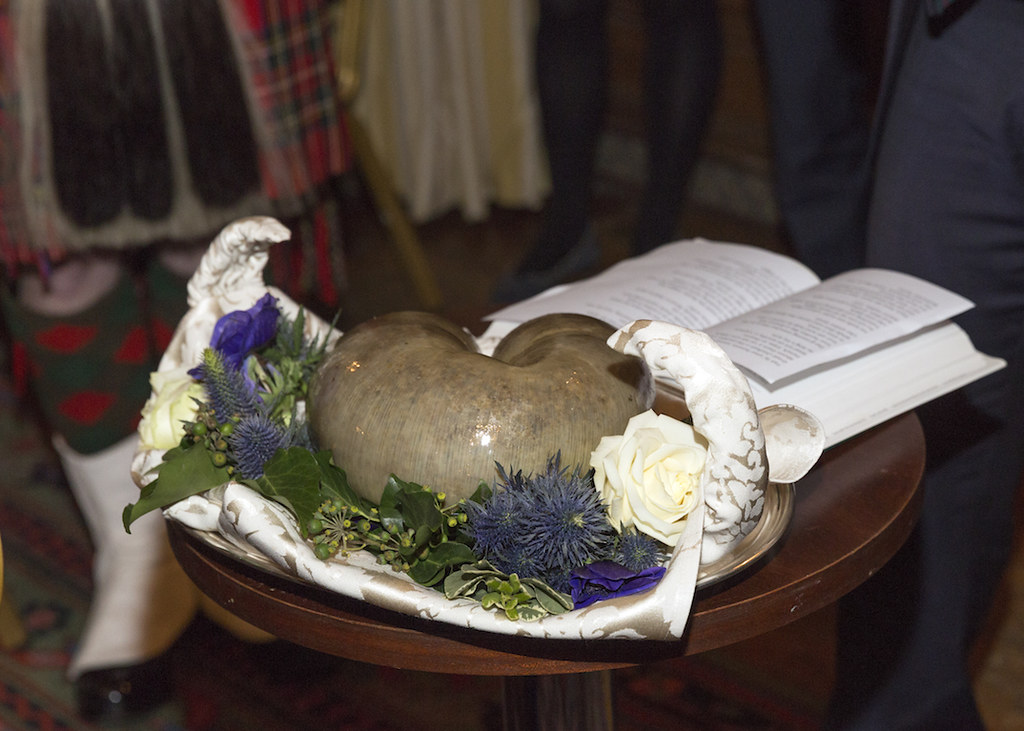 A haggis presented on a platter with thistles and tartan at a Burns supper